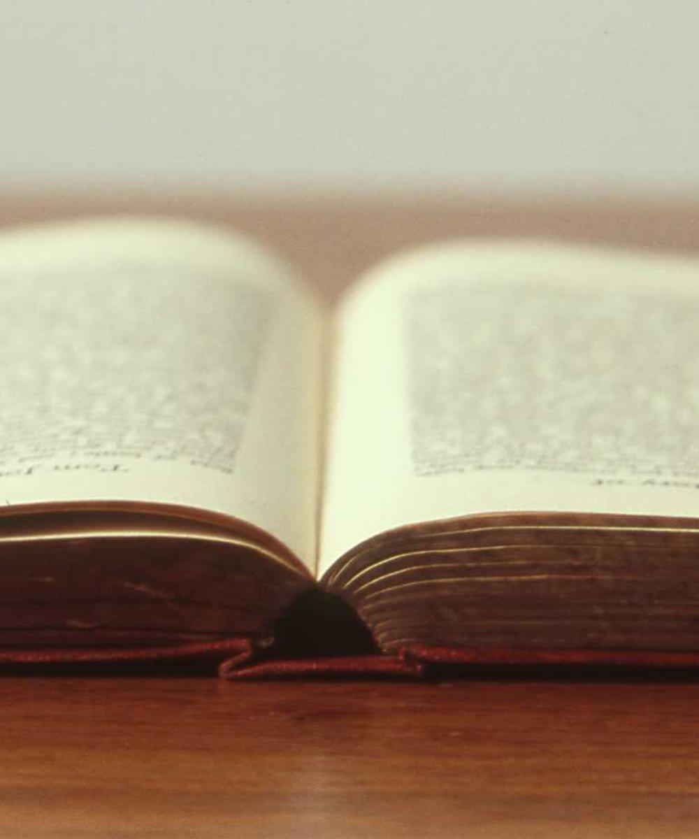 An open book resting on a wooden table